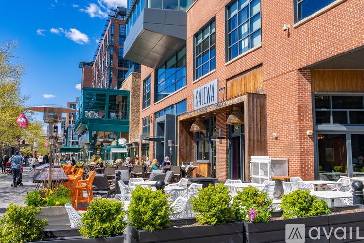 A sunny day at the Mallina building with people walking around and sitting on the outdoor seating area.
