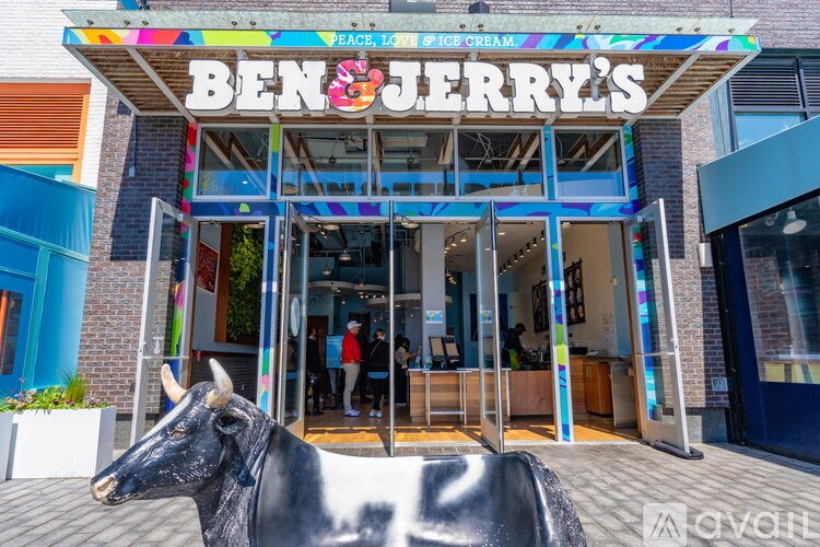 A black cow statue is in front of a colorful Ben & Jerry's store.