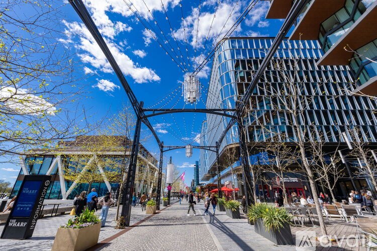 A modern building with glass windows and a walkway with people walking on it.