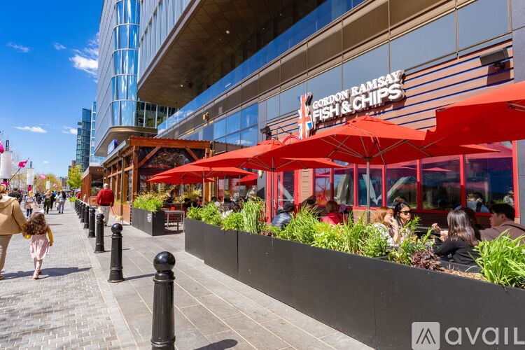 A restaurant named "London Ramsay Fish & Chips" is located on a sidewalk with red umbrellas and outdoor seating.