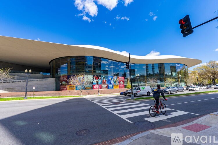 A cyclist is waiting at a red traffic light at an intersection.