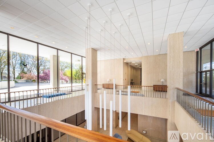 A modern atrium with a wooden railing and a glass wall.