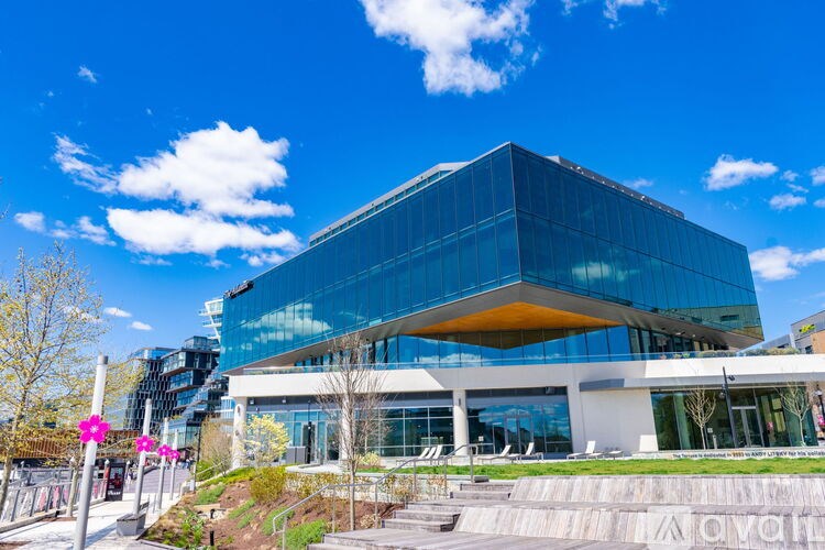 A modern glass building with a yellow awning and a clear blue sky above.