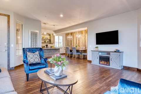 A living room with a blue chair and a fireplace.
