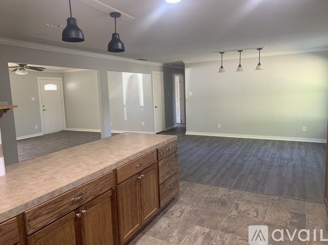 A kitchen with wooden cabinets and a countertop is available for rent.