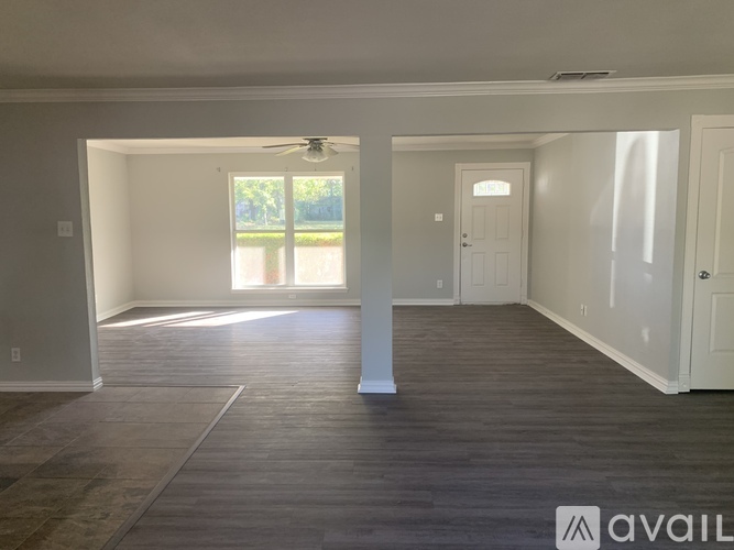 A spacious room with a fan and a door leading outside.