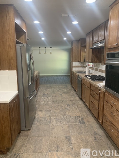 A kitchen with wooden cabinets and a tiled floor.