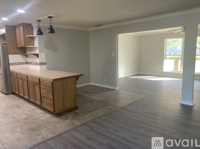 A kitchen with wooden cabinets and a countertop is available for rent.