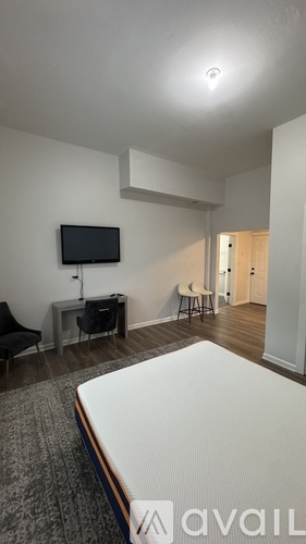 A bedroom with a bed, desk, and chair.