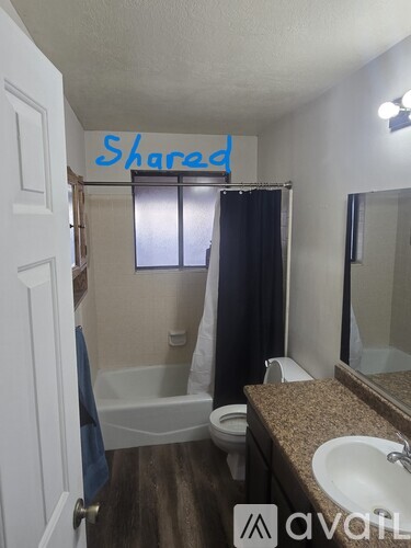 A bathroom with a toilet, sink, and a shower curtain.