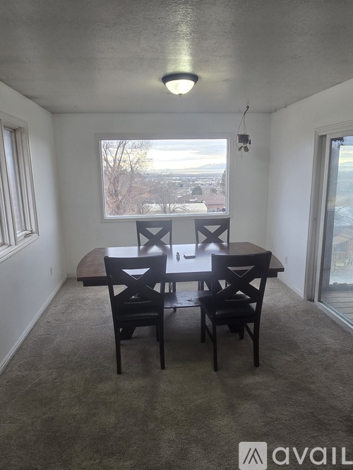 A dining room with a table and chairs.