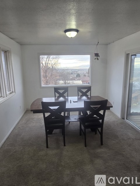 A dining room with a table and chairs.