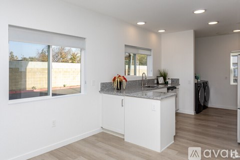 A kitchen with white cabinets and a granite countertop.