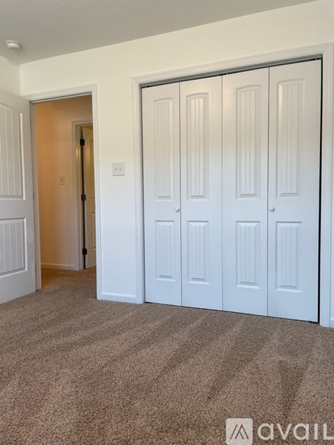 A room with white doors and a carpeted floor.