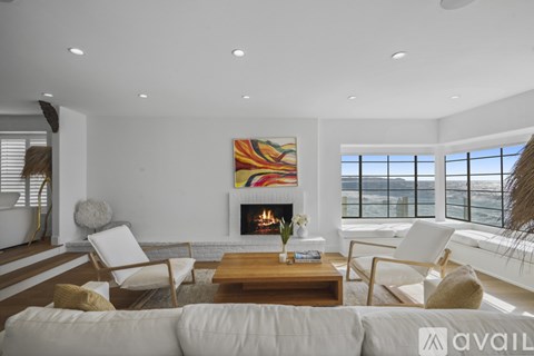 A modern living room with a fireplace and a large painting on the wall.