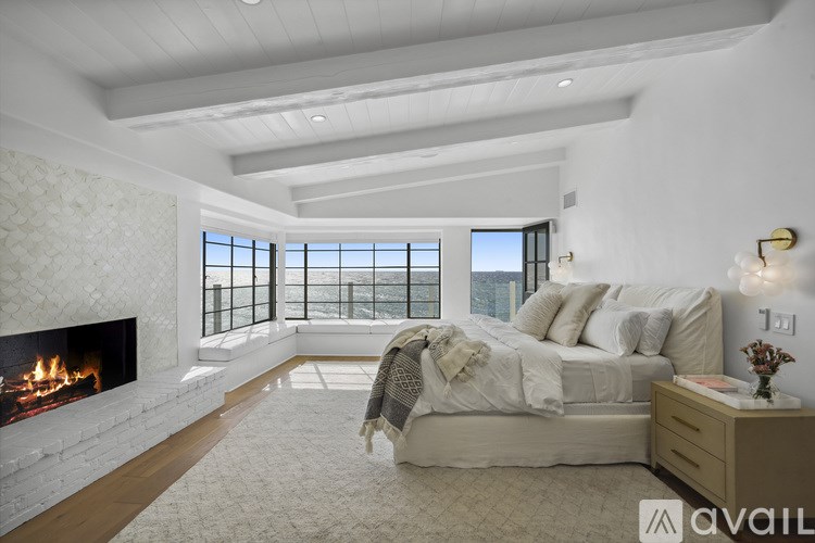 A bedroom with a large bed and a fireplace.
