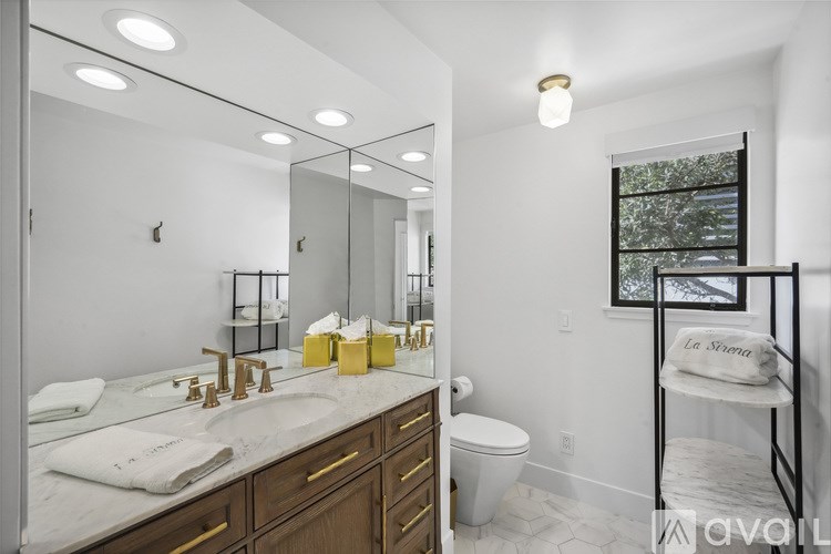 A bathroom with a marble countertop and a large mirror.