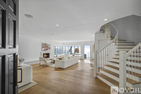 A spacious living room with a staircase on the right side.