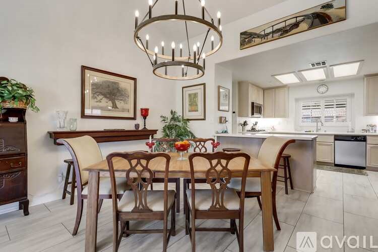 A dining room with a wooden table and chairs.