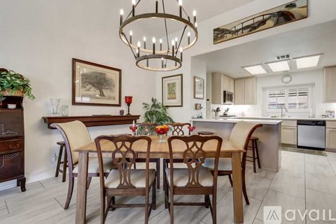 A dining room with a wooden table and chairs.
