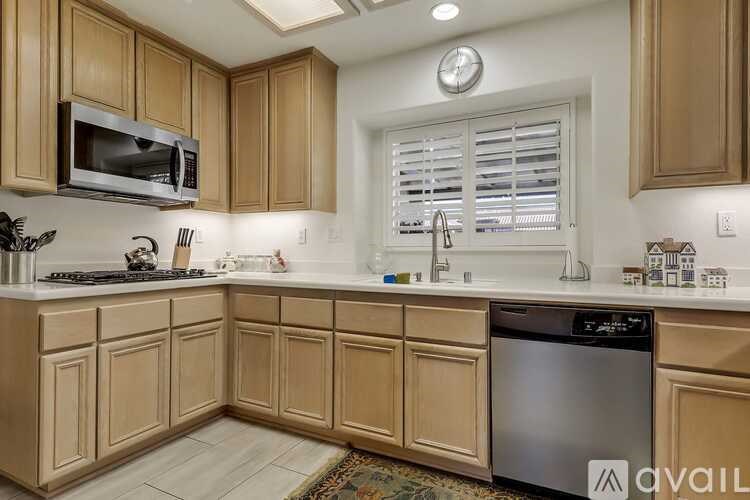 A kitchen with wooden cabinets and a stainless steel dishwasher.