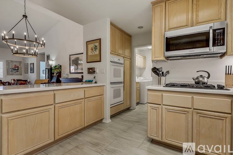 A kitchen with wooden cabinets and a chandelier.