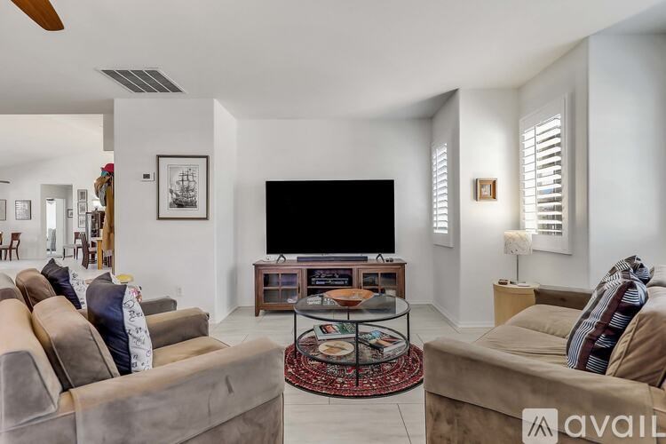 A living room with a large television and two couches.