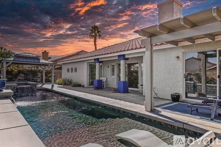 A house with a pool in front of it.