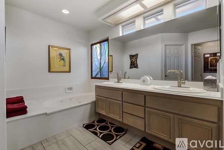 A bathroom with a tub, sink, and a window.