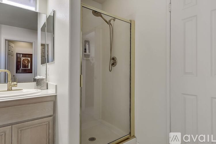A bathroom with a glass shower door and a white door.