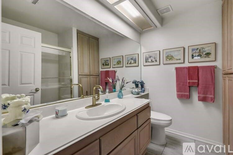 A bathroom with a white countertop and a toilet in the corner.