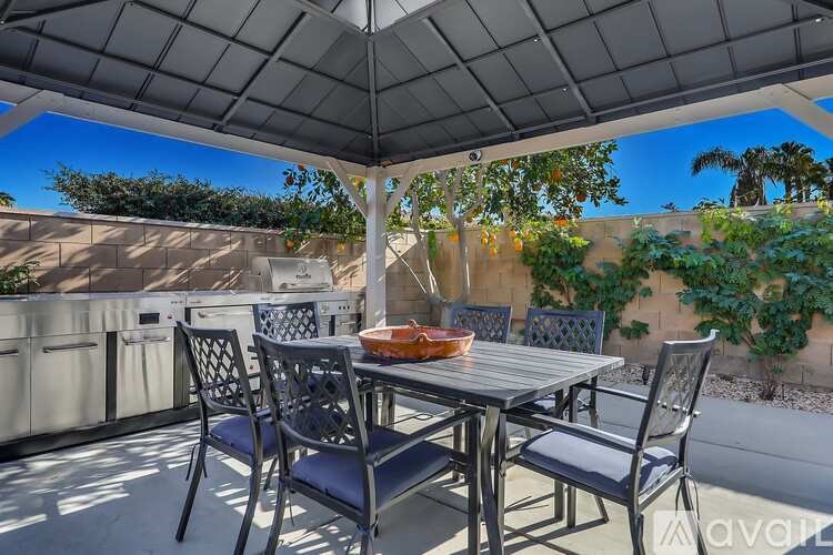 A patio with a table and chairs under a canopy.