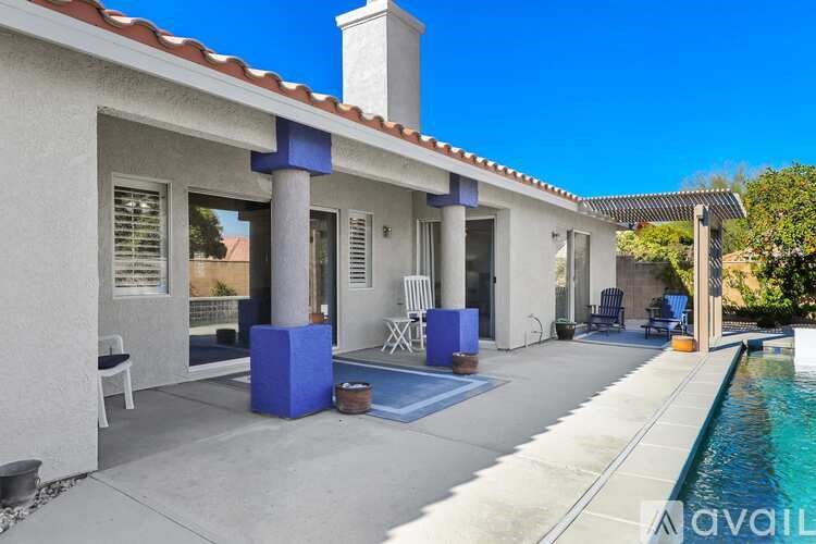 A house with a pool and a blue column.