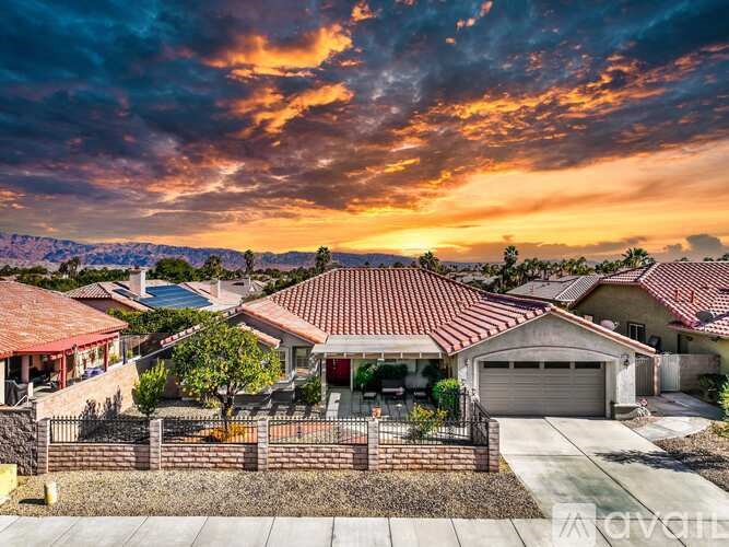 A sunset view of a neighborhood with houses and a clear sky.