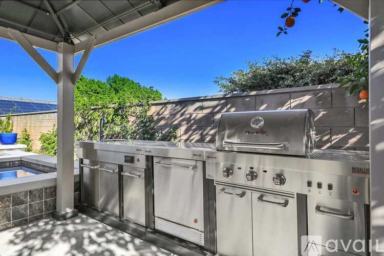 A stainless steel outdoor kitchen with a grill and sink.