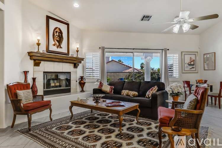 A living room with a fireplace and a painting on the wall.
