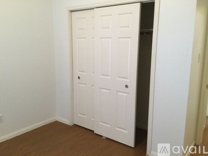 A white door in a room with wooden flooring.