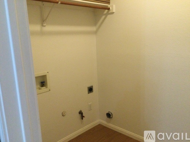 A room with a white wall and a brown floor.