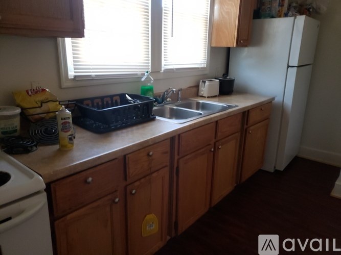 A kitchen with wooden cabinets and a white fridge.