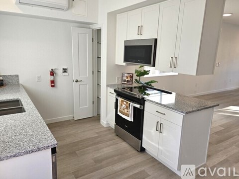 A kitchen with white cabinets and a granite countertop.