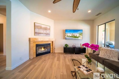 A living room with a fireplace and a painting on the wall.