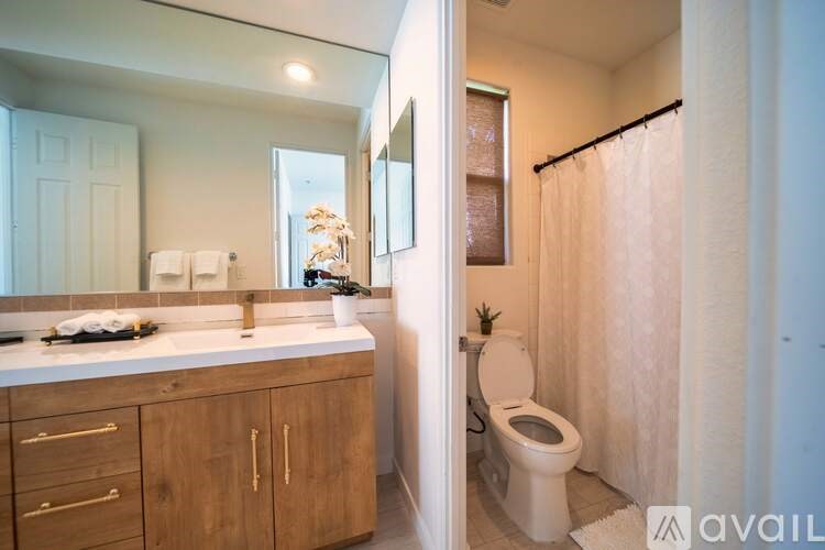 A bathroom with a toilet, sink, and mirror.