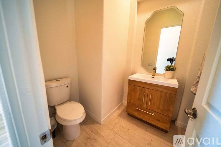 A bathroom with a toilet, sink, and mirror.