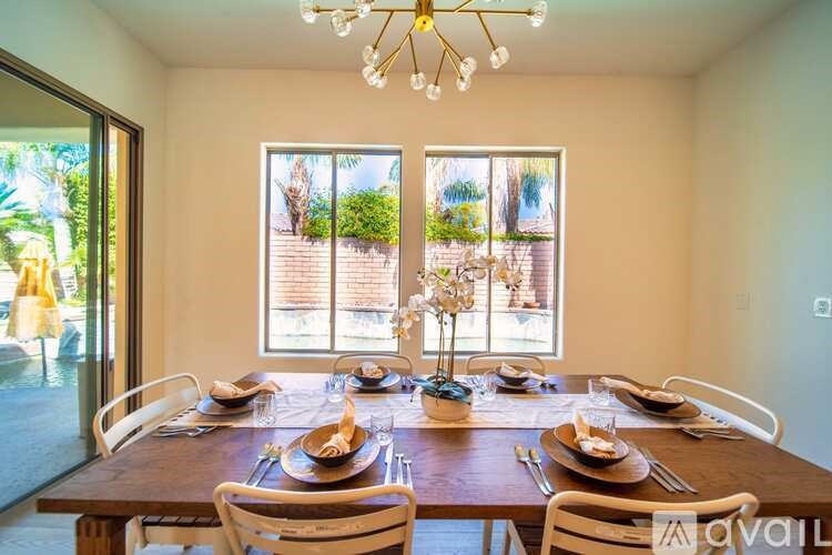 A dining room with a wooden table set for a meal.