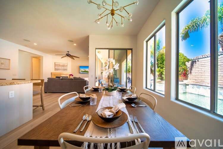 A modern dining room with a wooden table set for a meal.