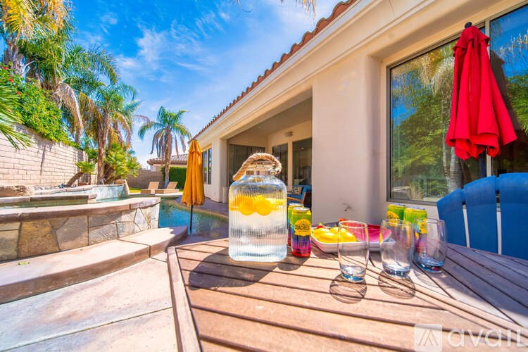 A table with drinks and a bottle of water on it.