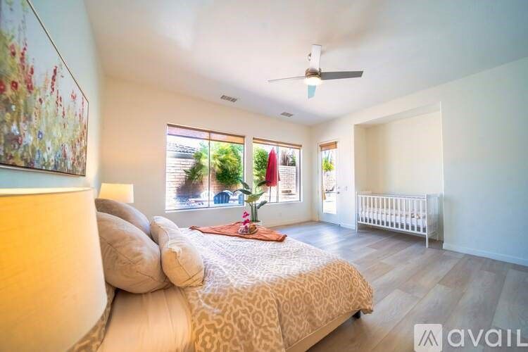 A bedroom with a large bed and a painting on the wall.