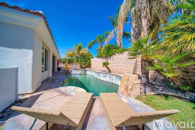 A house with a pool and a patio table.