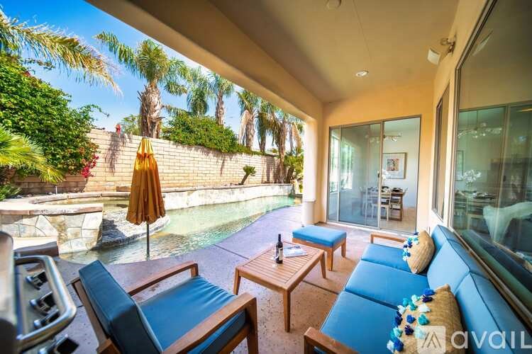 A sunny patio with a pool and a blue couch.