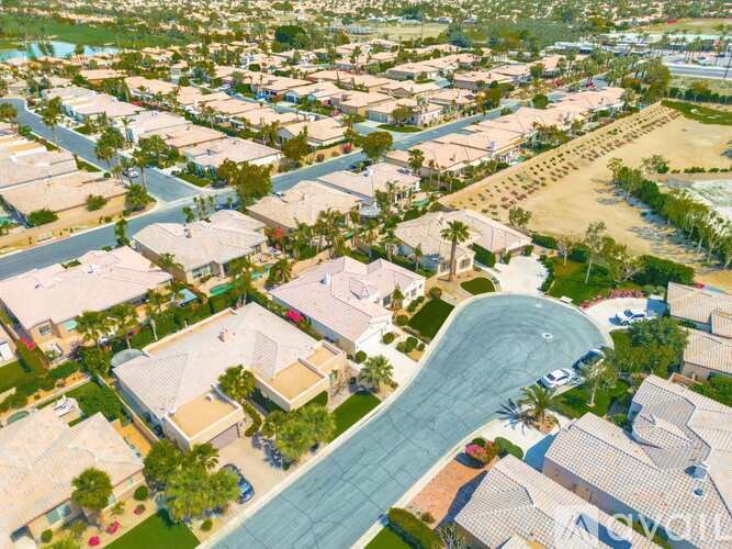 A residential area with a large swimming pool in the foreground.